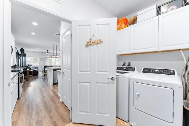 laundry area featuring washer and dryer, cabinets, light hardwood / wood-style flooring, and ceiling fan