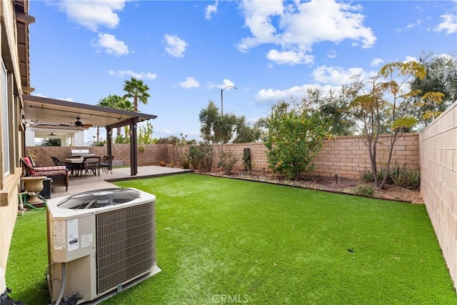 view of yard featuring ceiling fan, cooling unit, and a patio