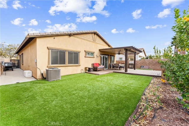 back of property with a deck, a pergola, a yard, and central AC