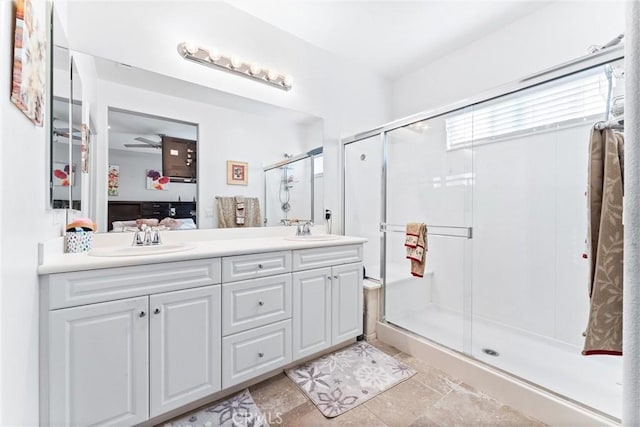 bathroom with a shower with shower door, vanity, and ceiling fan