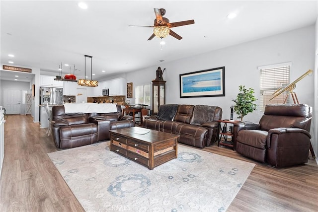 living room featuring ceiling fan and light hardwood / wood-style floors