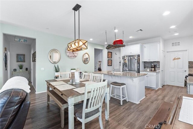 dining area featuring sink and wood-type flooring