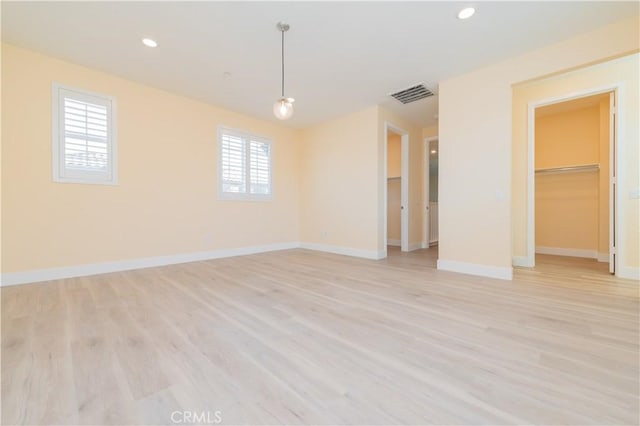 unfurnished room featuring a wealth of natural light and light hardwood / wood-style floors