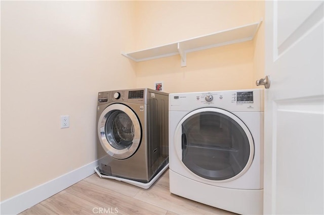 laundry area featuring light hardwood / wood-style floors and washing machine and dryer