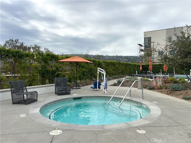 view of swimming pool with a hot tub