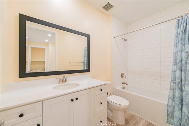 full bathroom featuring hardwood / wood-style floors, toilet, vanity, and shower / bathtub combination with curtain