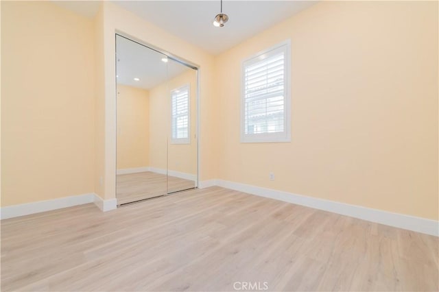 unfurnished bedroom with a closet and light wood-type flooring