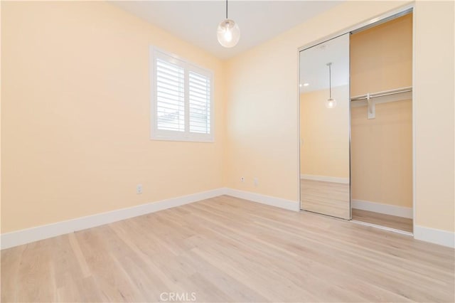 unfurnished bedroom featuring hardwood / wood-style flooring and a closet