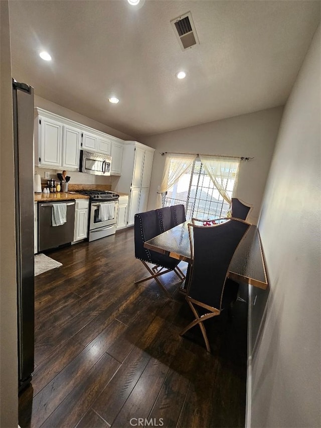 dining area with dark hardwood / wood-style floors and vaulted ceiling