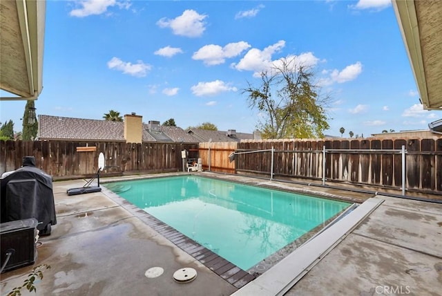 view of swimming pool featuring a patio area and grilling area