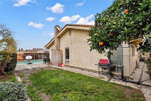 back of house featuring a fenced in pool and a yard