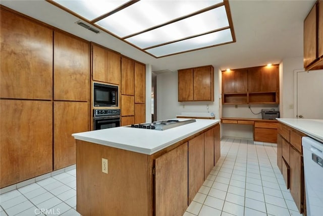 kitchen featuring light tile patterned floors, a center island, and black appliances