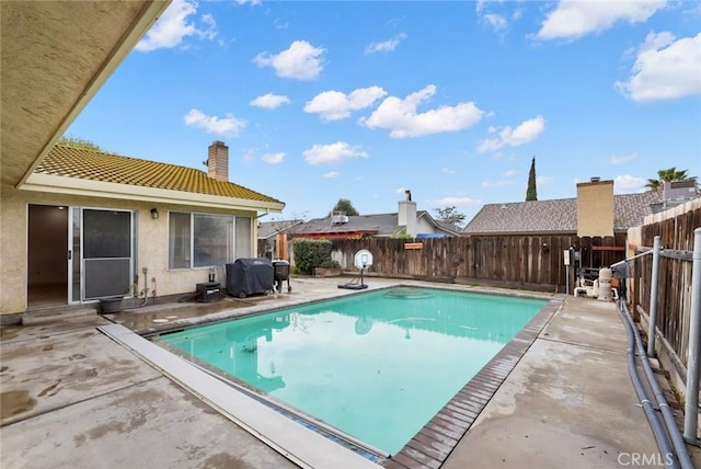 view of swimming pool with area for grilling and a patio