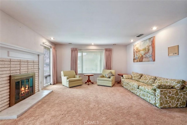 living room with a brick fireplace and carpet flooring