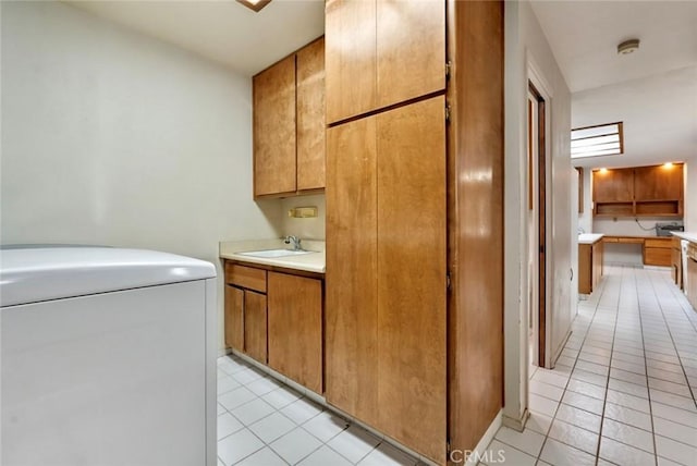 washroom with cabinets, light tile patterned floors, washer / dryer, and sink