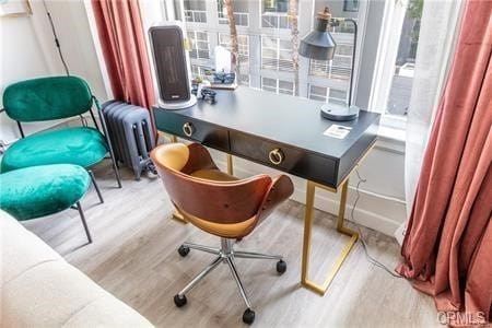 office featuring light hardwood / wood-style flooring and radiator heating unit