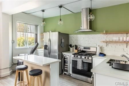 kitchen with white cabinetry, stainless steel appliances, sink, range hood, and a center island