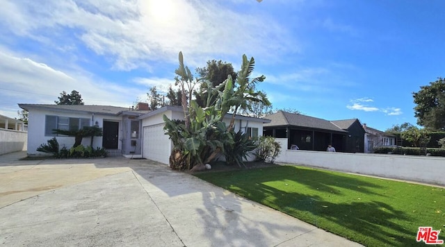 ranch-style house featuring a front lawn and a garage