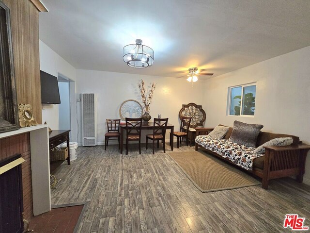 living room with dark wood-type flooring and ceiling fan with notable chandelier