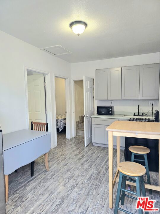 kitchen with gray cabinets and light hardwood / wood-style flooring