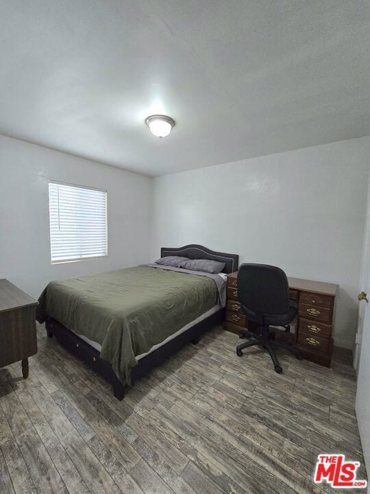 bedroom with dark hardwood / wood-style floors