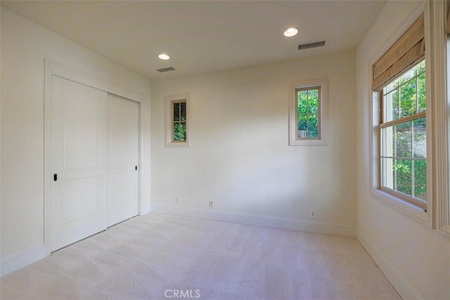 unfurnished bedroom featuring a closet and light carpet