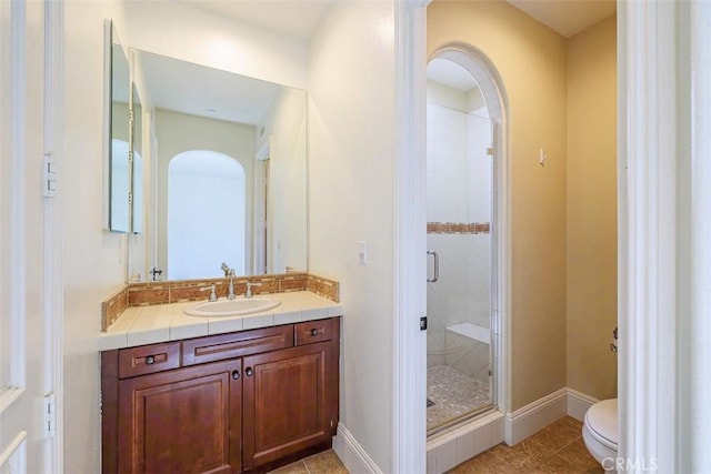 bathroom with a shower with shower door, tile patterned floors, toilet, and vanity