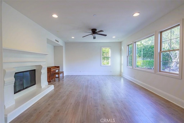 unfurnished living room featuring ceiling fan and wood-type flooring