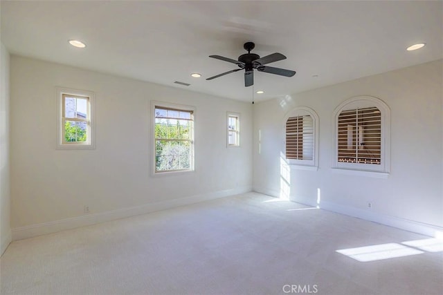 spare room featuring ceiling fan and light colored carpet