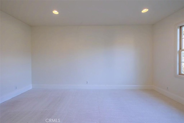 spare room featuring a healthy amount of sunlight and light colored carpet