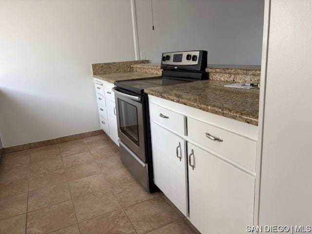 kitchen with white cabinetry, electric range, and dark stone counters