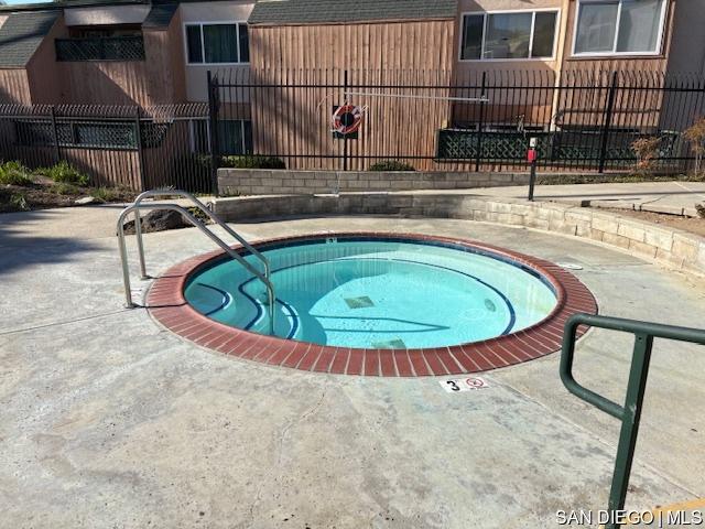 view of swimming pool featuring a hot tub