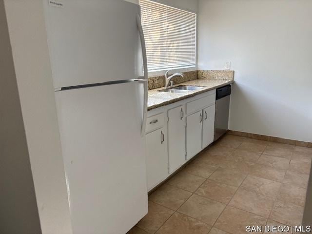 kitchen with stainless steel dishwasher, white cabinets, sink, and white fridge