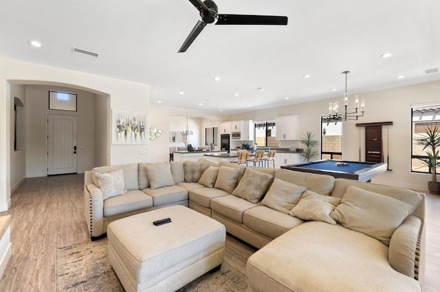 living room with billiards, ceiling fan with notable chandelier, and light hardwood / wood-style flooring