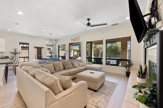 living room featuring pool table, ceiling fan with notable chandelier, and light hardwood / wood-style flooring