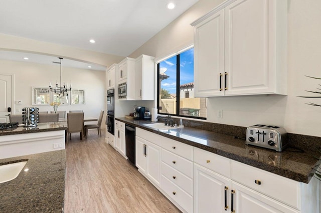 kitchen featuring pendant lighting, white cabinetry, and dark stone countertops