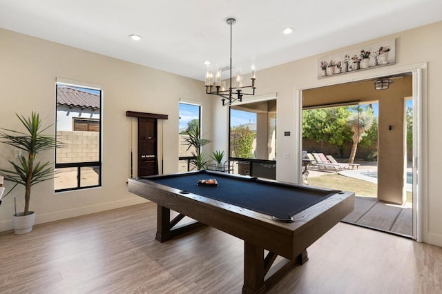 recreation room with plenty of natural light, hardwood / wood-style floors, pool table, and an inviting chandelier