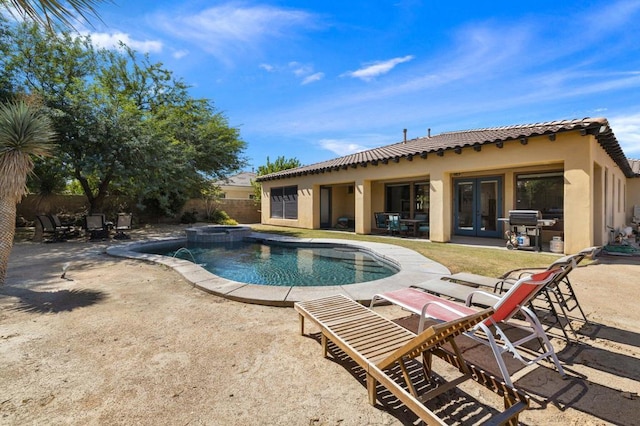 view of swimming pool with an in ground hot tub, a patio area, and a grill