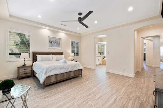 bedroom featuring ceiling fan, light hardwood / wood-style floors, and connected bathroom