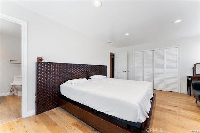 bedroom with hardwood / wood-style flooring and connected bathroom