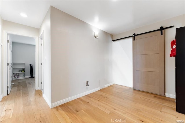 spare room with a barn door and hardwood / wood-style flooring