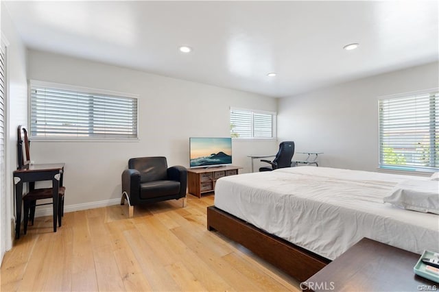 bedroom with light wood-type flooring and multiple windows