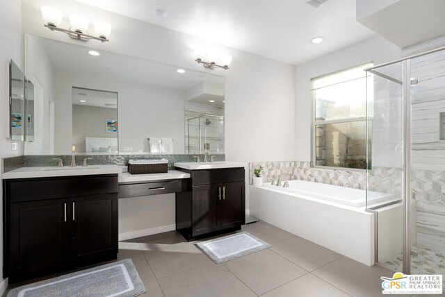 bathroom featuring plus walk in shower, vanity, and tile patterned flooring