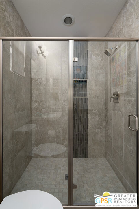 bathroom with toilet and walk in shower