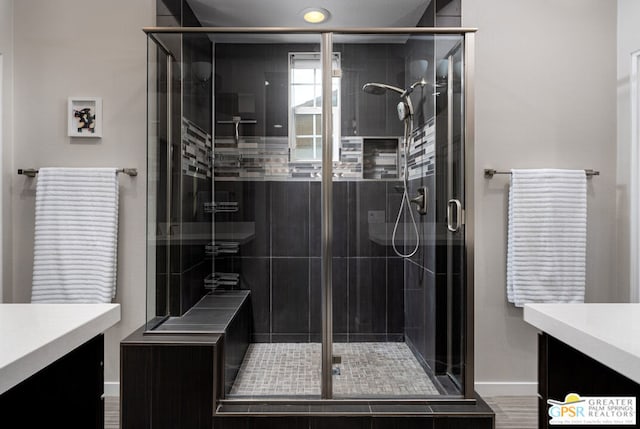 bathroom with a shower with door and vanity