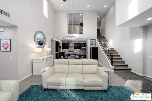 living room featuring light tile patterned flooring and a high ceiling