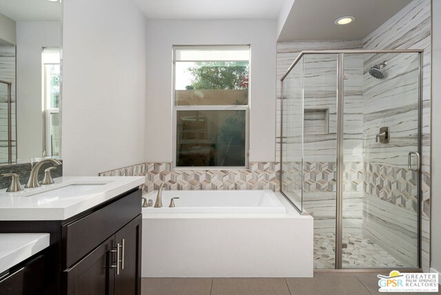 bathroom with tile patterned floors, vanity, separate shower and tub, and a healthy amount of sunlight