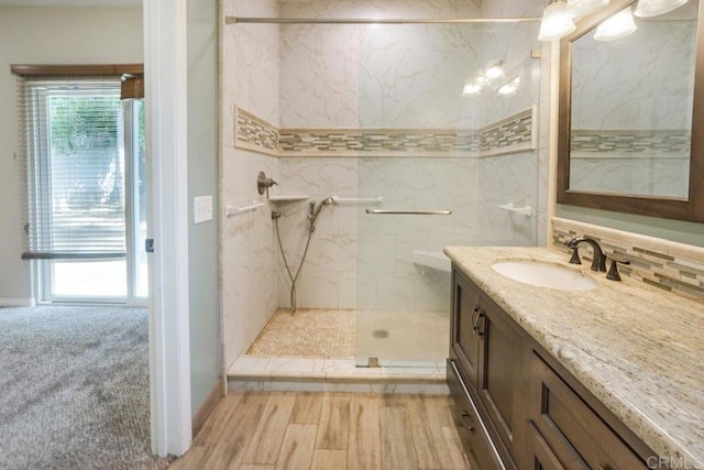 bathroom with vanity, decorative backsplash, and a tile shower