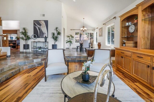 interior space with vaulted ceiling, a notable chandelier, and light hardwood / wood-style flooring