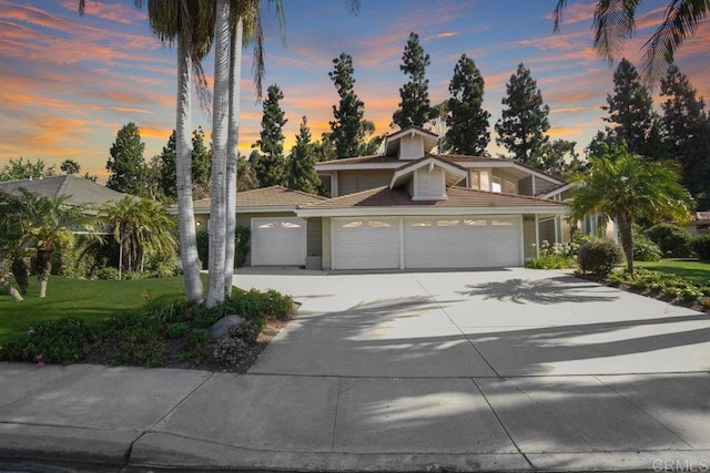 view of front of property with a garage and a yard